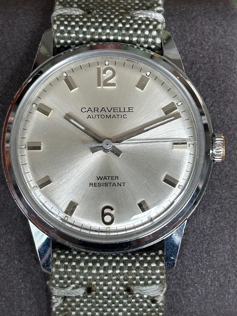 Vintage watch - Caravelle (by Bulova) automatic winding watch with green canvas strap.  swiss movement.  Serviced, running and keeping time.