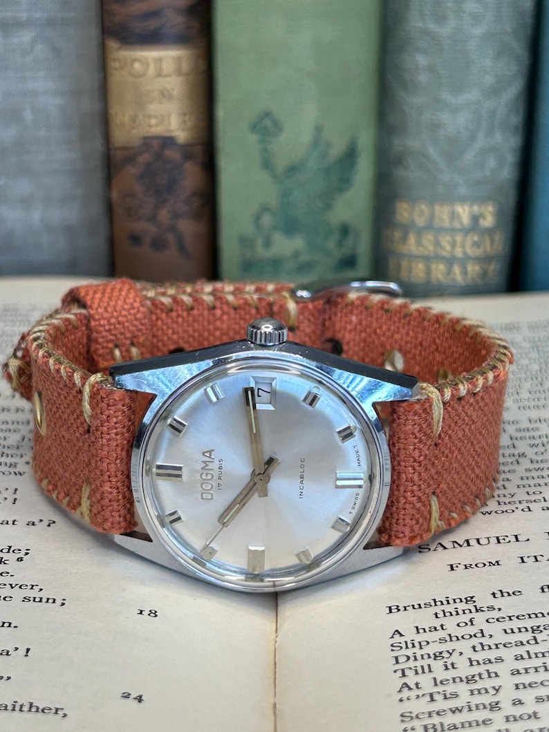 Vintage watch Dogma swiss watch with silver case and sweep seconds dial.  Has date window. New custom orange band and silver crown. Running, serviced, keeps time, working.