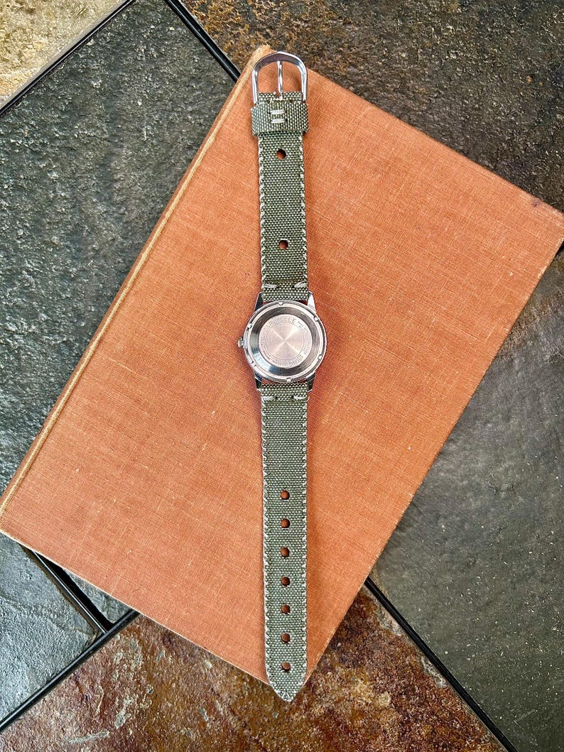 Vintage watch - Caravelle (by Bulova) automatic winding watch with green canvas strap.  swiss movement.  Serviced, running and keeping time.