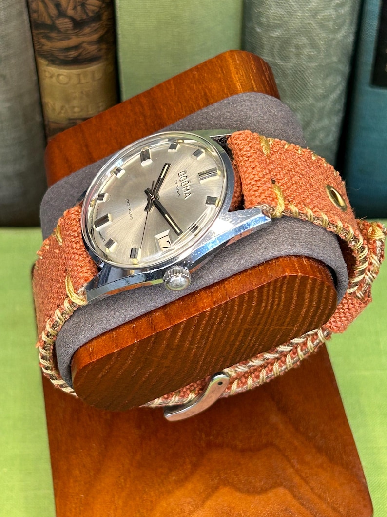 Vintage watch Dogma swiss watch with silver case and sweep seconds dial.  Has date window. New custom orange band and silver crown. Running, serviced, keeps time, working.