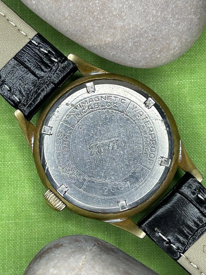 1950s era Fortis swiss watch with chrome plated case and copper colored hands, patina dial. New black leather band. Running, serviced, keeps time, working