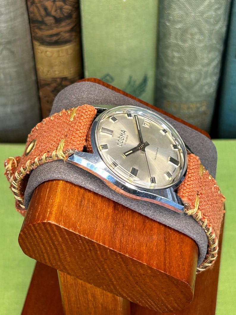 Vintage watch Dogma swiss watch with silver case and sweep seconds dial.  Has date window. New custom orange band and silver crown. Running, serviced, keeps time, working.