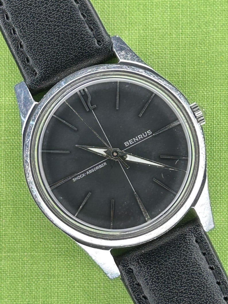 Vintage Benrus watch with black dial and stainless steel case.  Silver crown. New black leather band. Running, serviced, keeps time, working