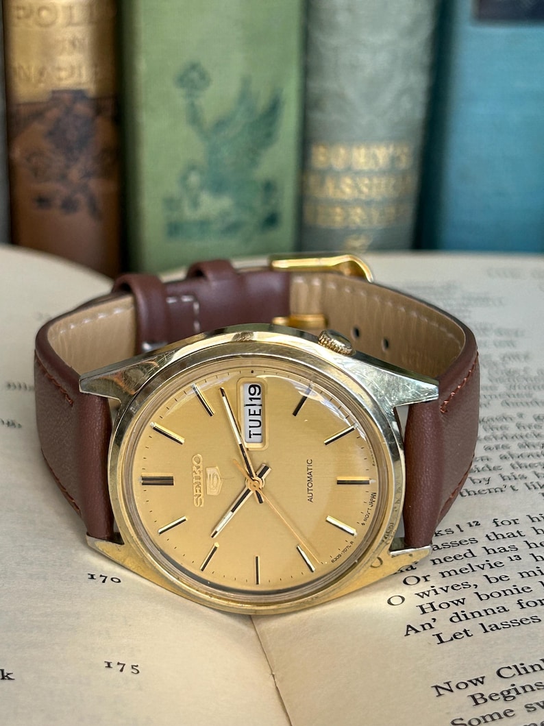 1980's era vintage Seiko automatic watch with gold dial and gold plated case.  Gold plated crown. New brown leather band. Running, serviced, keeps time, working