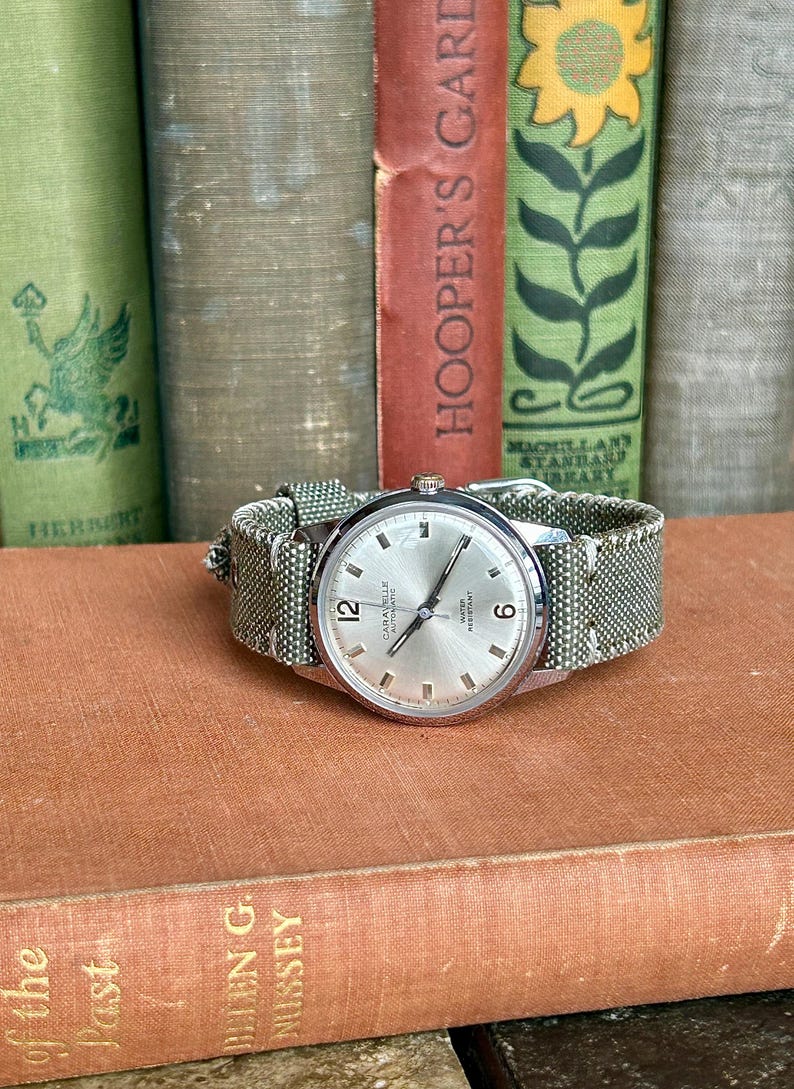 Vintage watch - Caravelle (by Bulova) automatic winding watch with green canvas strap.  swiss movement.  Serviced, running and keeping time.