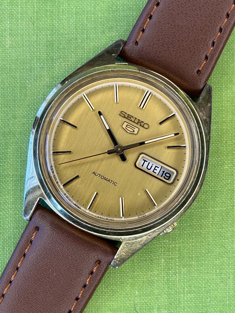 1980's era vintage Seiko automatic watch with gold dial and gold plated case.  Gold plated crown. New brown leather band. Running, serviced, keeps time, working