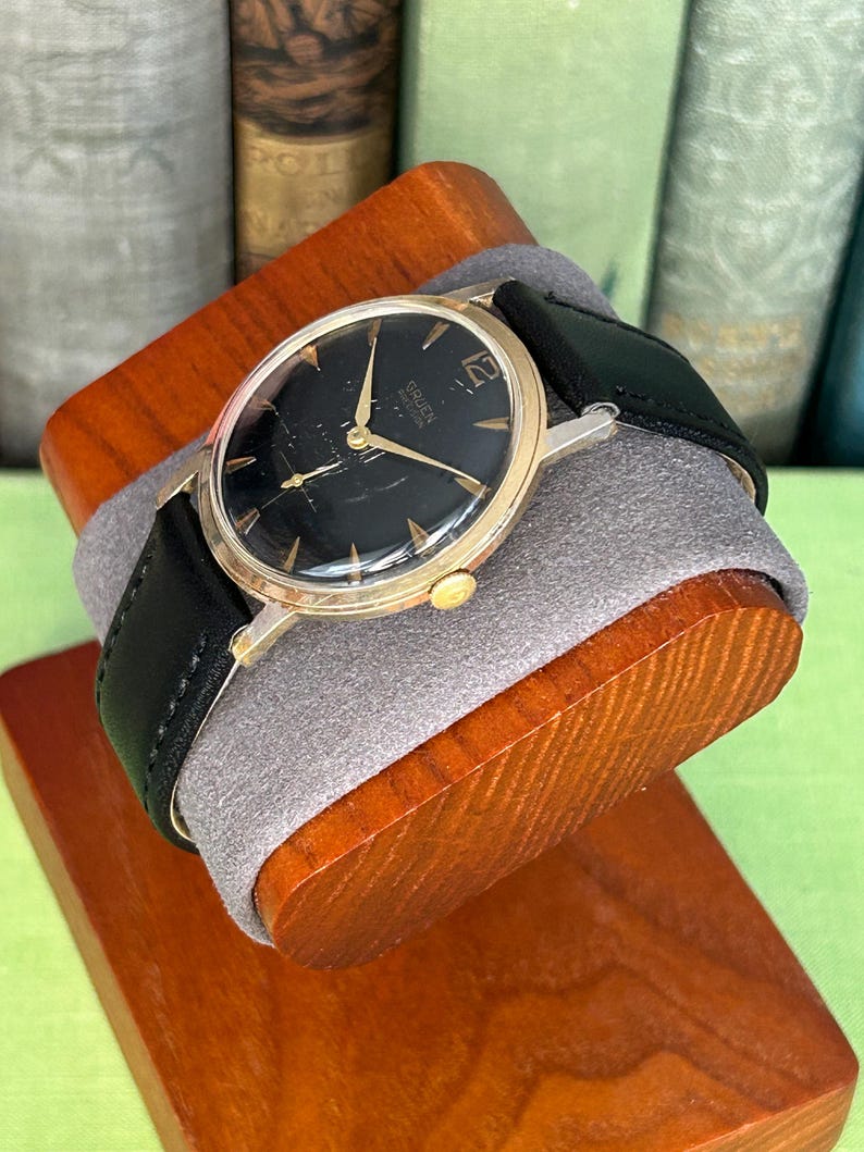 Vintage 1960s Gruen Precision watch.  Black leather band.  Running, serviced, keeps time, working.  Gold plated case with black dial