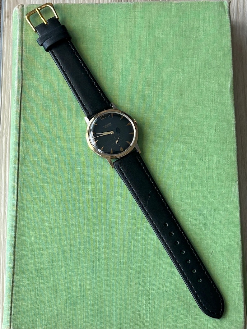 Vintage 1960s Gruen Precision watch.  Black leather band.  Running, serviced, keeps time, working.  Gold plated case with black dial