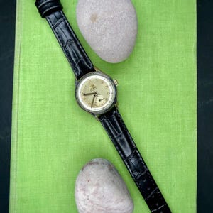 1950s era Fortis swiss watch with chrome plated case and copper colored hands, patina dial. New black leather band. Running, serviced, keeps time, working