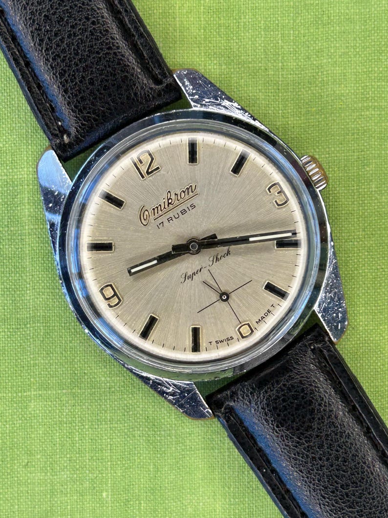 Vintage watch Omikron swiss watch with silver case and small seconds dial.  black leather band and silver crown. Running, serviced, keeps time, working.