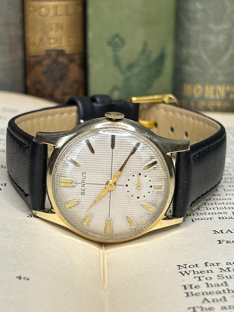 1950s Vintage Benrus crosshair watch with waffle dial and round gold plated case.  Gold crown. New black leather band. Running, serviced, keeps time, working