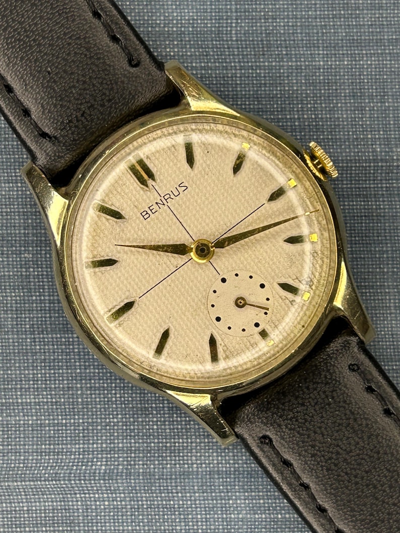 1950s Vintage Benrus crosshair watch with waffle dial and round gold plated case.  Gold crown. New black leather band. Running, serviced, keeps time, working