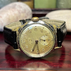1950s era Fortis swiss watch with chrome plated case and copper colored hands, patina dial. New black leather band. Running, serviced, keeps time, working