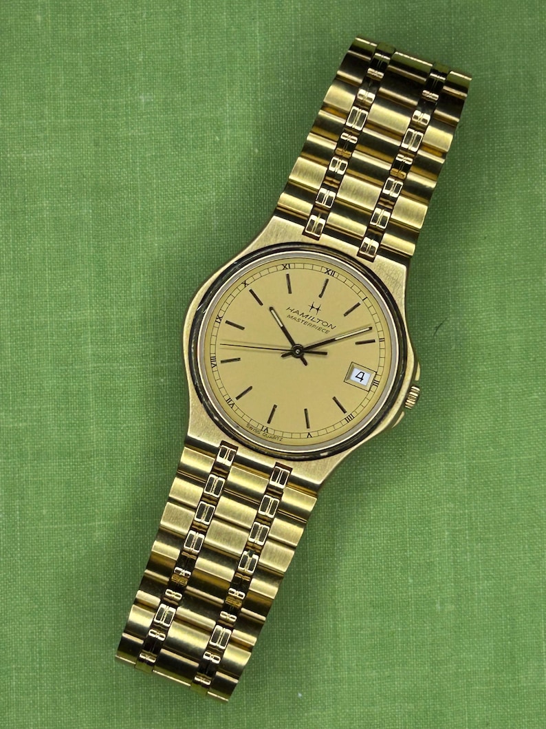 Hamilton Masterpiece Quartz watch model 9162a with gold plated case and original bracelet. Date window.  Running, keeping time, fresh battery.