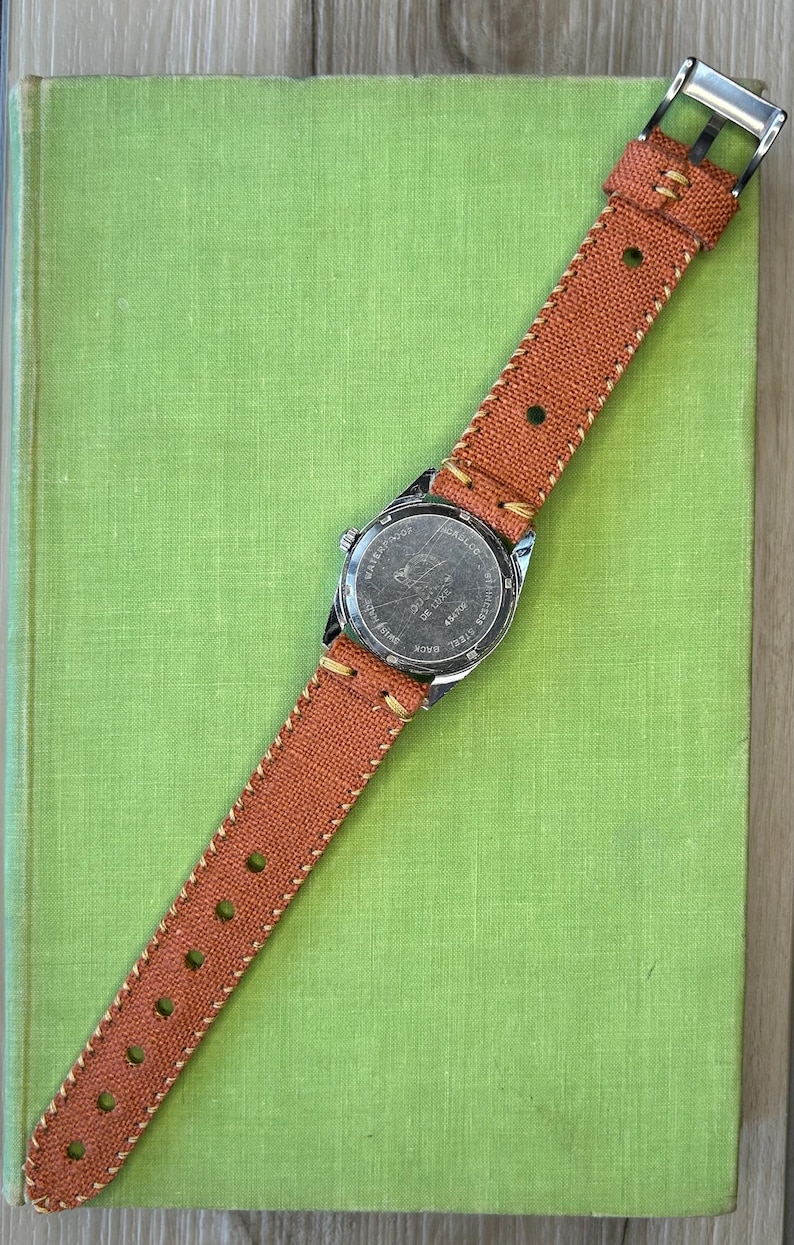 Vintage watch Dogma swiss watch with silver case and sweep seconds dial.  Has date window. New custom orange band and silver crown. Running, serviced, keeps time, working.