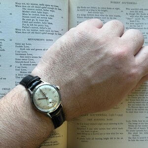 1950s era Fortis swiss watch with chrome plated case and copper colored hands, patina dial. New black leather band. Running, serviced, keeps time, working