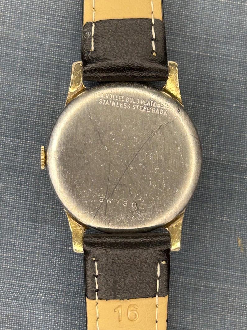 1950s Vintage Benrus crosshair watch with waffle dial and round gold plated case.  Gold crown. New black leather band. Running, serviced, keeps time, working
