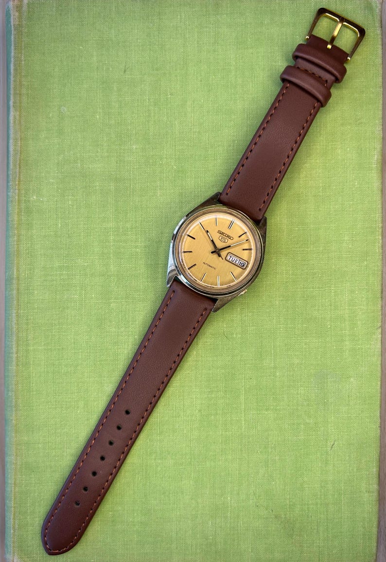 1980's era vintage Seiko automatic watch with gold dial and gold plated case.  Gold plated crown. New brown leather band. Running, serviced, keeps time, working