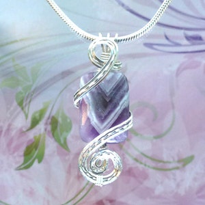 May include: A silver chain necklace with a purple and white striped stone pendant wrapped in silver wire.