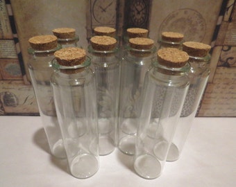 Peut inclure: Dix bouteilles en verre transparent avec des bouchons en liège. Les bouteilles sont cylindriques et ont un fond arrondi. Les bouchons sont bruns et ont une finition naturelle.