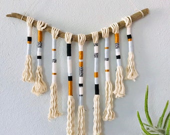 Yarn wrapped tassel wallhanging in cool neutrals