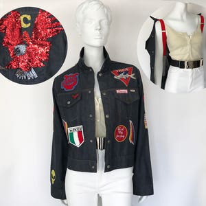 Peut inclure: Une veste en jean bleu foncé avec divers patchs brodés, dont un drapeau mexicain rouge, blanc et bleu, un aigle rouge et un avion rouge et blanc. La veste a un logo YNCK au dos.
