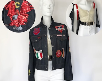 Könnte beinhalten: Eine dunkelblaue Jeansjacke mit verschiedenen gestickten Aufnähern, darunter eine rot-weiß-blaue mexikanische Flagge, ein roter Adler und ein rot-weißes Flugzeug. Die Jacke hat ein YNCK-Logo auf der Rückseite.