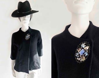 Chaqueta bolero negra con broche enjoyado, estilo vintage de los años 80, de lana auténtica, con mangas dolman 3/4 y pedrería recortada.