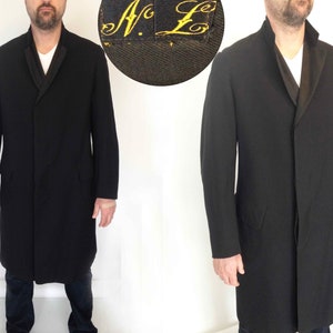 May include: A black long coat with a black satin collar. The coat has a single button closure and two pockets. The label on the coat reads "N.E."