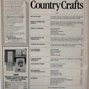 May include: A magazine cover for Country Crafts, featuring a variety of crafts including a summer pullover, embroidered coveralls, and a checkerboard pattern. The magazine cover is from 1987 and features a list of crafts and their corresponding page numbers.