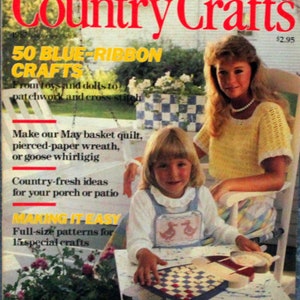 May include: A magazine cover for Country Crafts featuring a girl playing a checkerboard game on a white table. The magazine cover has a yellow title and the text "50 Blue-Ribbon Crafts" in yellow. The text "Making It Easy" is in red. The magazine cover also features a woman sitting in a white chair with a yellow and white crocheted top.