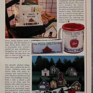 May include: Image of cross-stitch designs. It shows a tote bag with "Jenny's Book Bag", a mug with "Miss Smith is an A+ Teacher", and a stitched village with buildings like a bank and school.