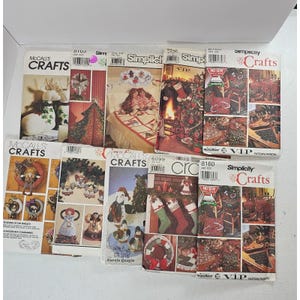 May include: A collection of McCall's and Simplicity craft pattern booklets. The covers feature images of Christmas decorations, wreaths, and other holiday-themed crafts. The booklets are in various sizes and colors.