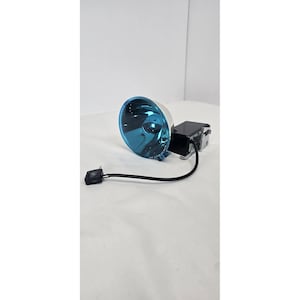 May include: A silver and black electronic device with a blue lens. The device has a black power cord and a small black switch. The lens is a bright, reflective blue color.