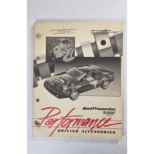 Pode incluir: Um catálogo Dodge vintage com ilustrações de motores de automóveis e um carro esportivo. A capa apresenta a palavra "Performance" em escrita vermelha, junto com "Driving Accessories". O catálogo é da Great Northern Dodge, Inc.