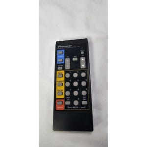 May include: Black Pioneer remote control with multiple buttons. The remote has buttons labeled "Power", "Vol", "Mute", "Menu", "Cursor", "Enter", and "Order". It also has number buttons and a "Recall" button.