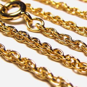 May include: Close-up of a gold rope chain necklace. The chain is made of multiple strands of linked oval-shaped links.