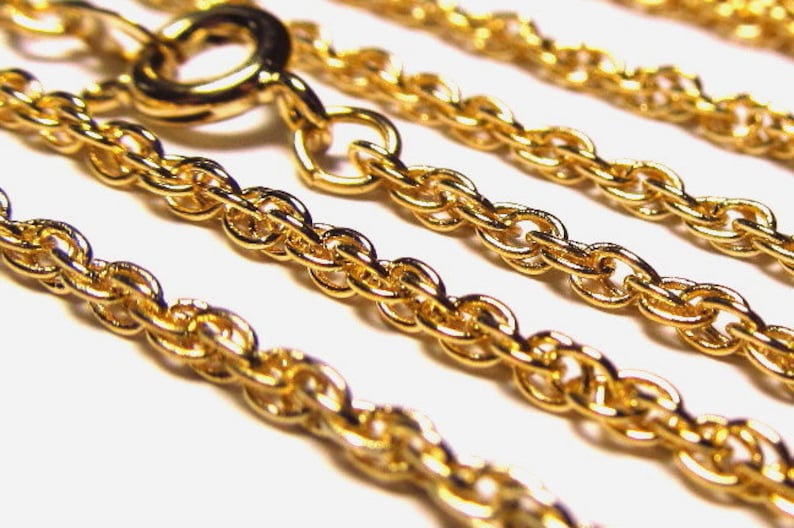 May include: Close-up of a gold rope chain necklace. The chain is made of multiple strands of linked oval-shaped links.
