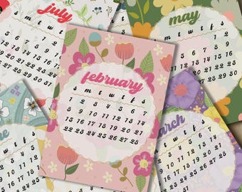 May include: A selection of floral calendars, each displaying a different month. The calendars have a circular design with the month's name in a decorative font. The colour palette includes pink, green, and white, with floral illustrations.