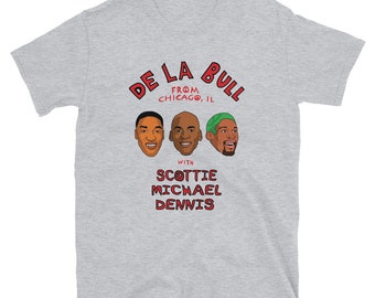 May include: Gray t-shirt with a red graphic design that says "De La Bull from Chicago, IL with Scottie Michael Dennis". The graphic also features three cartoon portraits of basketball players.