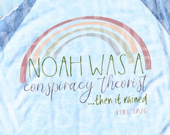 May include: A heather white and premium heather gray long-sleeved t-shirt with a rainbow graphic and the text "NOAH WAS A conspiracy theorist...then it rained - LUKE 17:26"