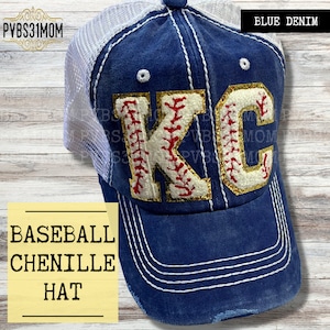 May include: A blue denim baseball cap with a white mesh back. The front of the cap features a gold glitter chenille "KC" with red stitching and white baseball stitching. The text "BLUE DENIM" is visible in the upper right corner of the image. The text "BASEBALL CHENILLE HAT" is visible in the lower left corner of the image.