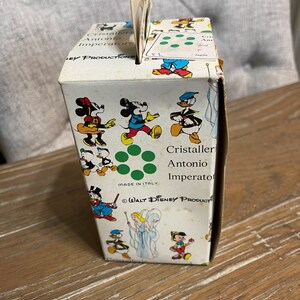May include: A white cardboard box with a green and red design featuring various Disney characters, including Mickey Mouse, Donald Duck, and a fairy. The box is labeled "Cristaller Antonio Imperatore" and "WALT DISNEY PRODUCTS".