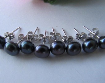 Puede incluir: Un juego de seis pares de pendientes de perlas negras. Cada pendiente tiene una perla redonda de color gris oscuro con un poste de plata y un cierre de mariposa.