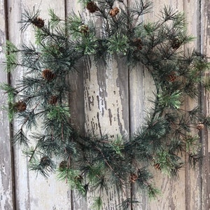 May include: A green pine wreath with brown pine cones, perfect for a rustic holiday decor.