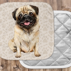 May include: A tan and white pug dog with a pink tongue sticking out is sitting on a beige background with paw prints and bone patterns. The dog is looking at the camera. The background is a quilted fabric with a white border.