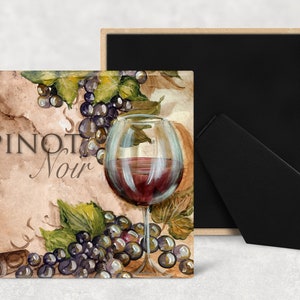 May include: A square coaster with a watercolor painting of a glass of red wine and grapes. The text "Pinot Noir" is written in brown script on the coaster.