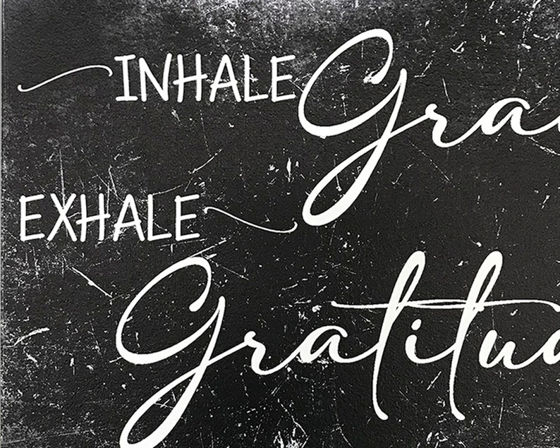 May include: Black and white sign with the text "INHALE GRACE EXHALE GRATITUDE" written in a cursive font.