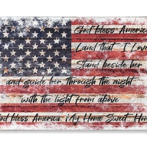 May include: A distressed wood sign with a faded American flag design and the text "God Bless America Land That I Love Stand Beside Her And Guide Her Through The Night With The Light From Above God Bless America My Home Sweet Home".