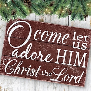 May include: A rustic wooden sign with a red background and white lettering. The sign reads "O come let us adore HIM Christ the Lord".